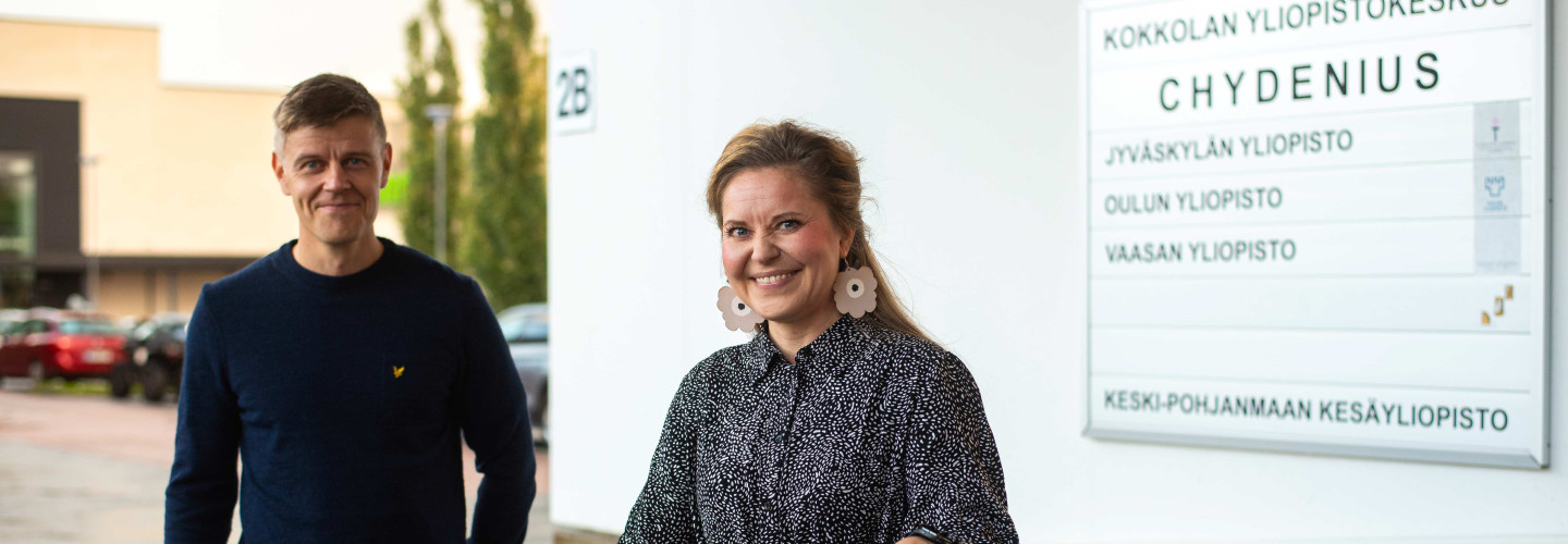 Kaksi opiskelijaa yliopistokeskuksen sisäänkäynnillä